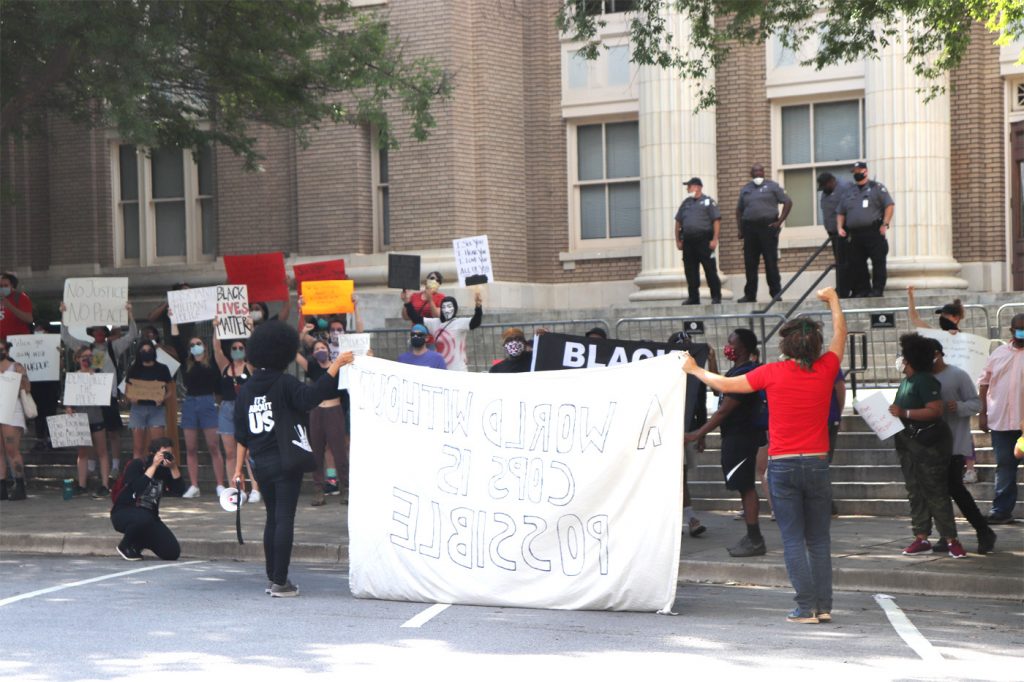 Protesters hold large banner at courthouse