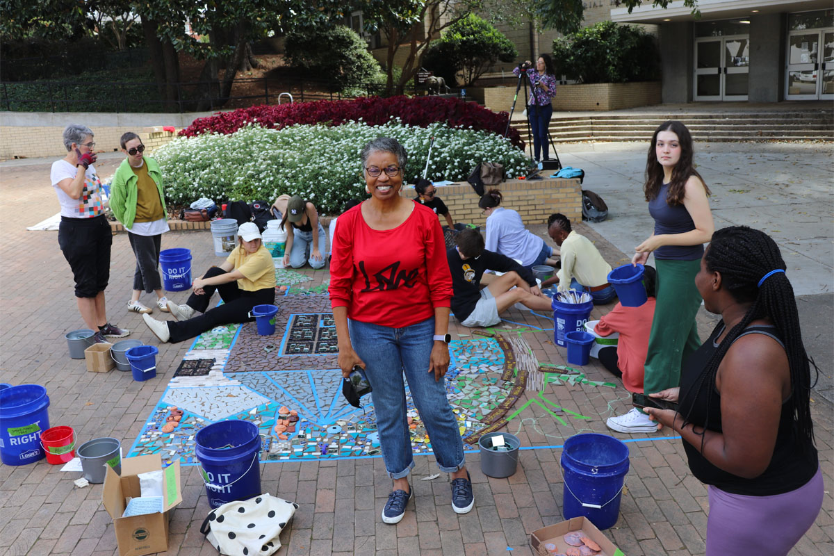 Hattie Whitehead standing in front of the Linnentown mosaic being installed