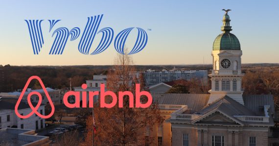 An Airbnb and VRBO logo over a photo of city hall